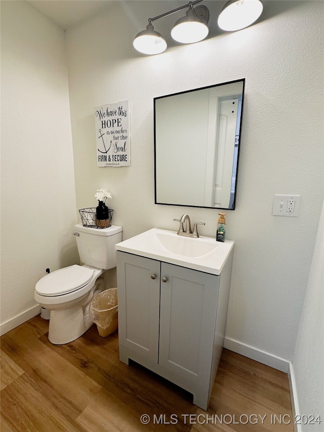 bathroom with hardwood / wood-style flooring, vanity, and toilet