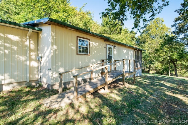 exterior space with a deck and a lawn