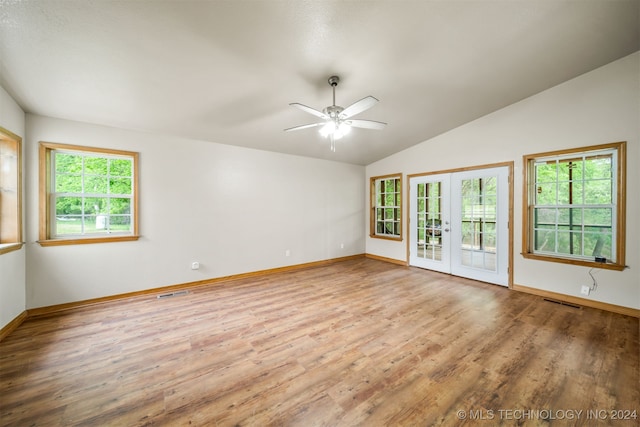 empty room featuring french doors, light hardwood / wood-style flooring, vaulted ceiling, and ceiling fan