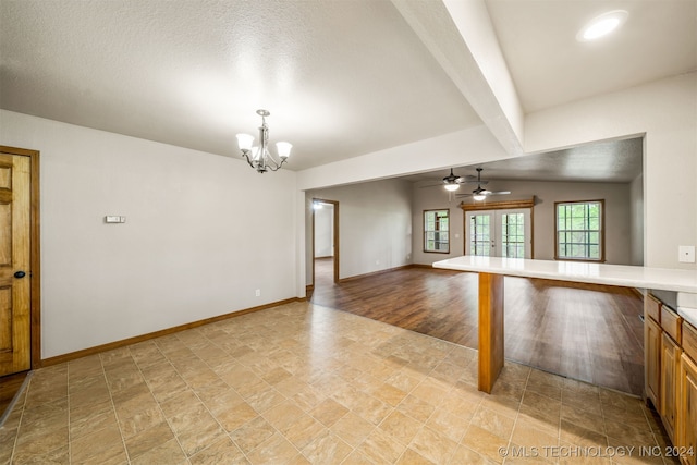 interior space with lofted ceiling with beams, light wood-type flooring, a textured ceiling, ceiling fan with notable chandelier, and french doors