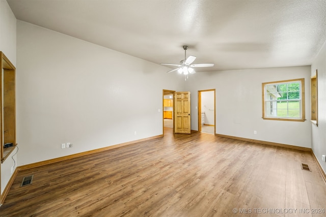 unfurnished room featuring wood-type flooring, a textured ceiling, lofted ceiling, and ceiling fan