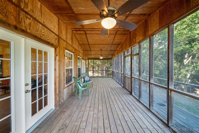 unfurnished sunroom with ceiling fan, wood ceiling, lofted ceiling, and a wealth of natural light