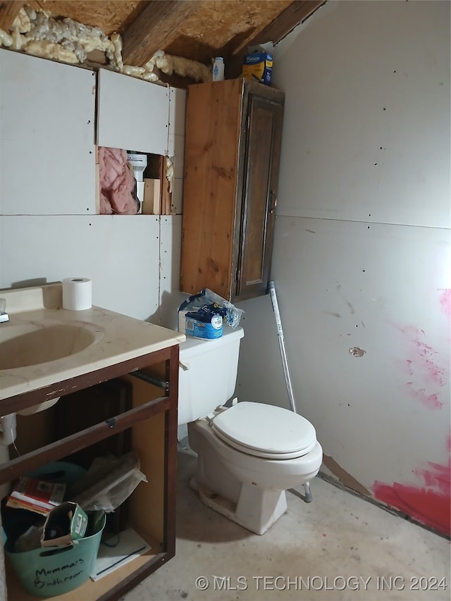 bathroom with vanity, toilet, and concrete floors