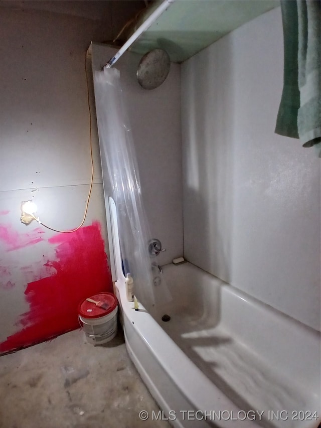 bathroom featuring shower / bath combo and concrete flooring