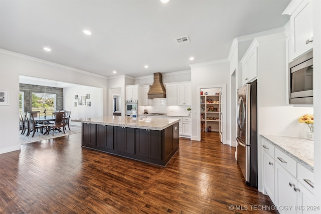 kitchen with white cabinets, an island with sink, dark wood-type flooring, stainless steel appliances, and custom range hood