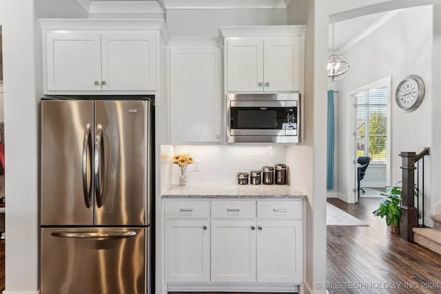 kitchen with light stone counters, tasteful backsplash, white cabinetry, appliances with stainless steel finishes, and dark hardwood / wood-style flooring