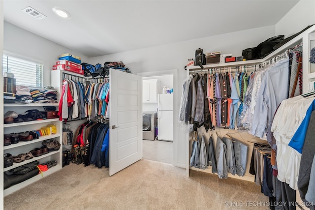 walk in closet featuring washer / clothes dryer and light colored carpet