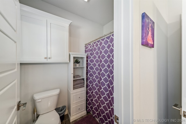 bathroom with toilet and a shower with shower curtain