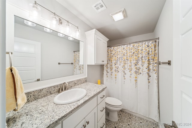 bathroom with a shower with curtain, vanity, toilet, and tile patterned floors