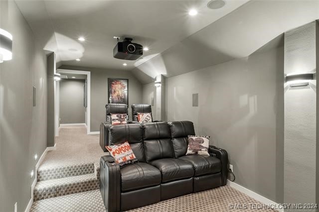 home theater room with lofted ceiling and light colored carpet