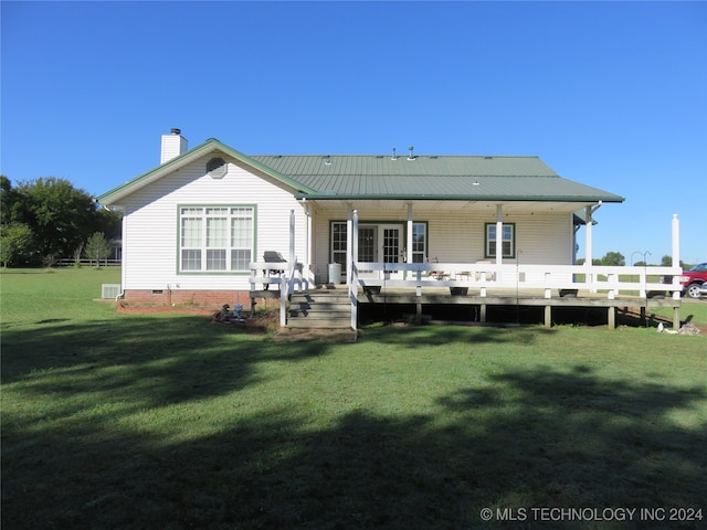 rear view of property featuring a deck and a yard