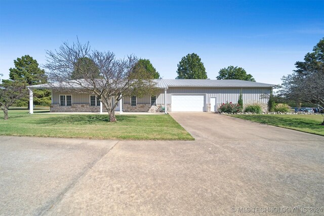 1202 SW 9th St, Wagoner, OK 74467 - single story home with a garage, board and batten siding, driveway, and stone siding