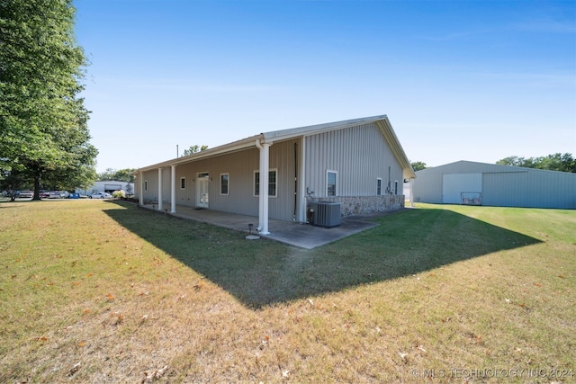 back of property with a lawn, cooling unit, and a patio area