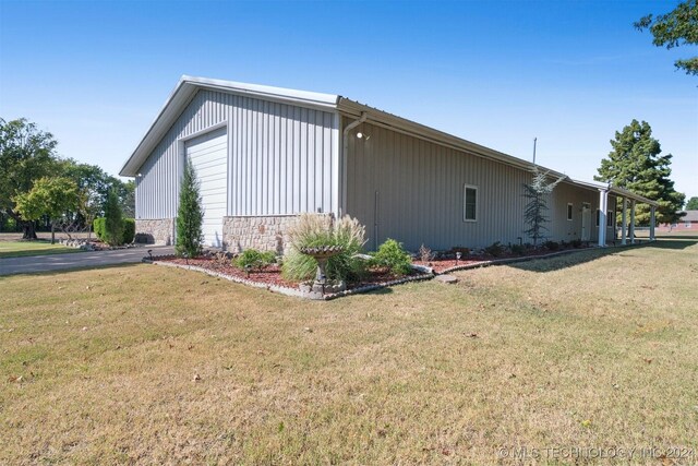 1202 SW 9th St, Wagoner, OK 74467 - view of home's exterior featuring a lawn, stone siding, and a garage