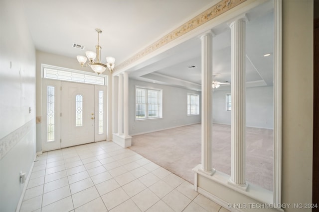 carpeted entryway featuring ceiling fan with notable chandelier and decorative columns