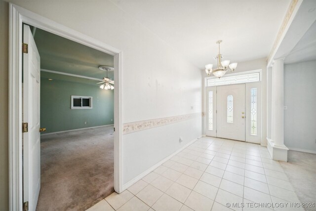 1202 SW 9th St, Wagoner, OK 74467 - entryway with baseboards, decorative columns, light tile patterned floors, and ceiling fan with notable chandelier