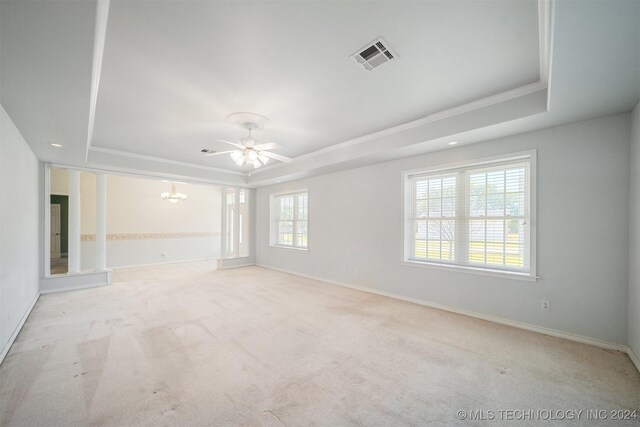 1202 SW 9th St, Wagoner, OK 74467 - carpeted spare room featuring visible vents, crown molding, baseboards, a tray ceiling, and ceiling fan with notable chandelier