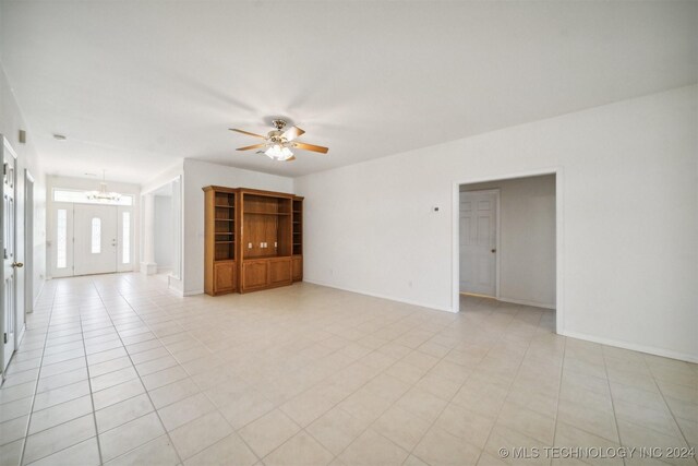 1202 SW 9th St, Wagoner, OK 74467 - empty room with baseboards, ceiling fan with notable chandelier, and light tile patterned floors