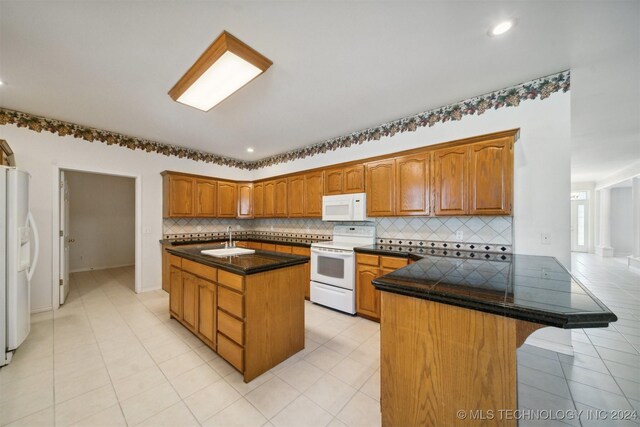 1202 SW 9th St, Wagoner, OK 74467 - kitchen with decorative backsplash, a peninsula, white appliances, a sink, and light tile patterned floors