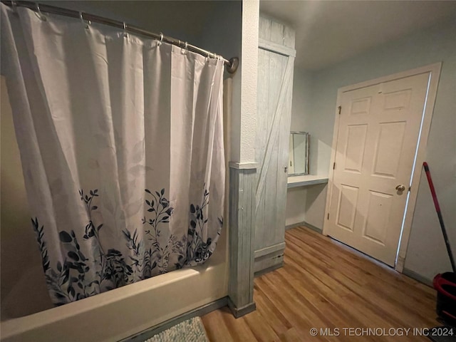 595 N 4340th Rd, Fort Towson, OK 74735 - full bathroom featuring wood finished floors, shower / bathtub combination with curtain, and baseboards