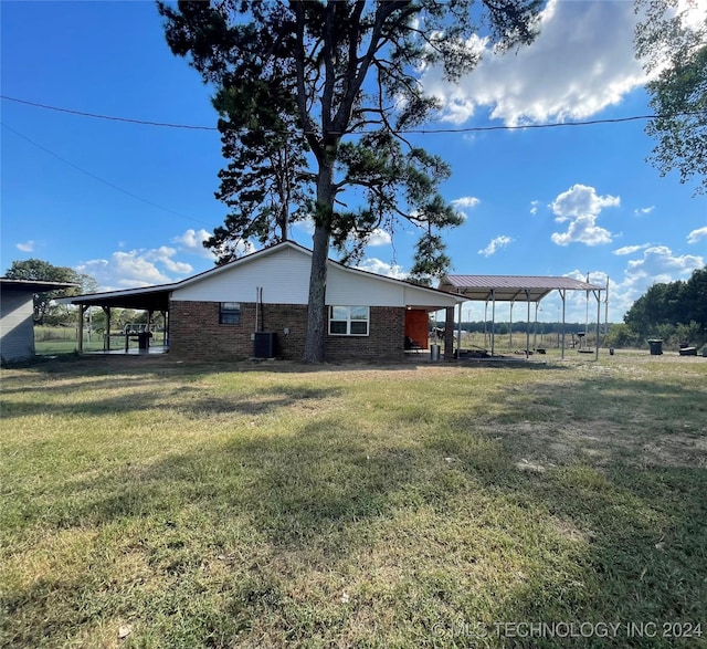 595 N 4340th Rd, Fort Towson, OK 74735 - view of property exterior featuring a yard, brick siding, and central AC