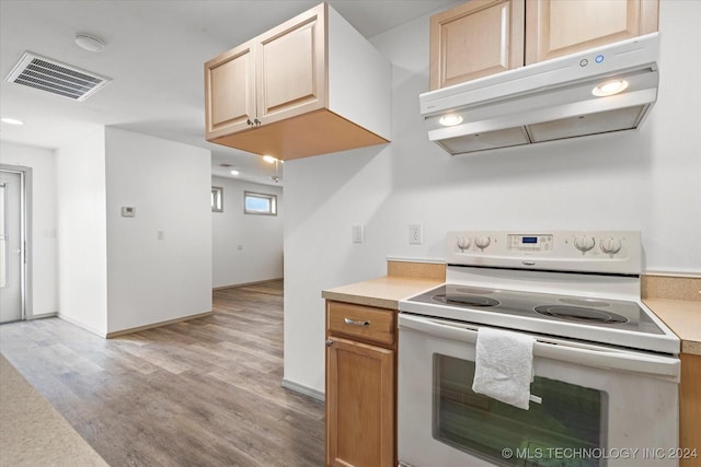 kitchen with light wood-type flooring, light brown cabinets, and white range with electric stovetop