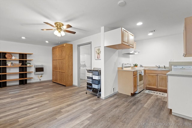 kitchen with heating unit, sink, stacked washer / drying machine, electric range, and light hardwood / wood-style floors