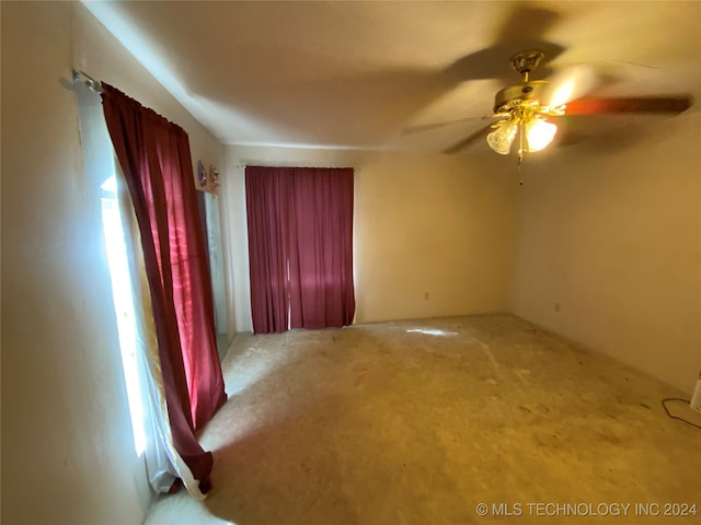 carpeted spare room with ceiling fan and plenty of natural light