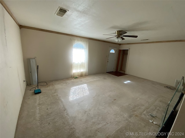 empty room featuring ceiling fan and crown molding