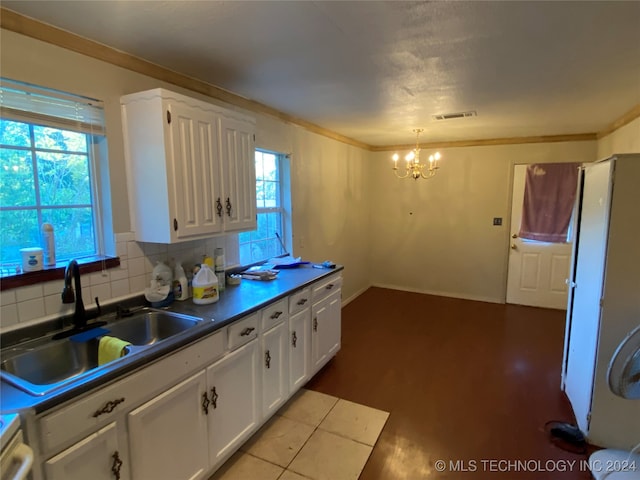 kitchen with a healthy amount of sunlight, white cabinetry, and sink