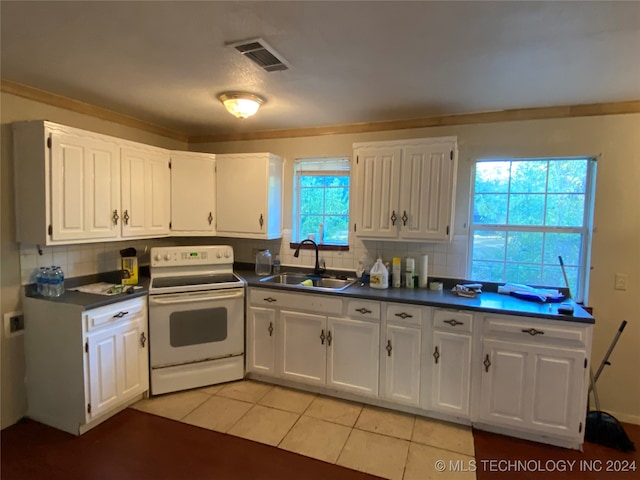 kitchen featuring electric stove, white cabinets, backsplash, and sink