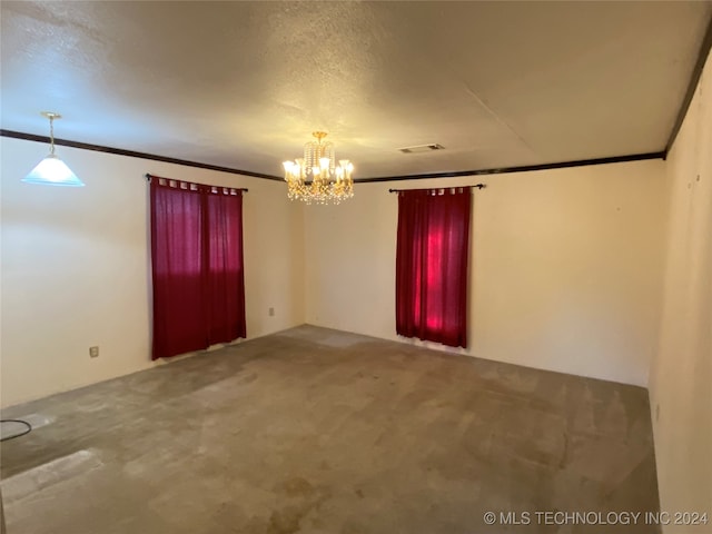 unfurnished room with an inviting chandelier, carpet, a textured ceiling, and crown molding