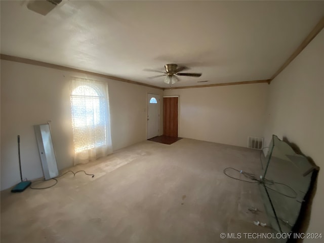 carpeted spare room featuring ceiling fan and ornamental molding