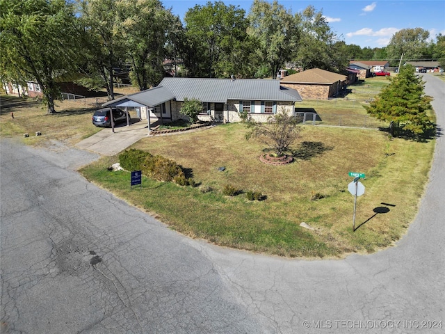1421 S Hayes Ave, Wagoner, OK 74467 - view of front of property featuring a front lawn, metal roof, asphalt driveway, an attached carport, and view of scattered trees
