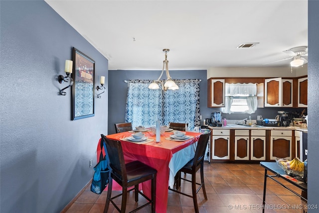 1421 S Hayes Ave, Wagoner, OK 74467 - dining room with dark tile patterned flooring and a chandelier