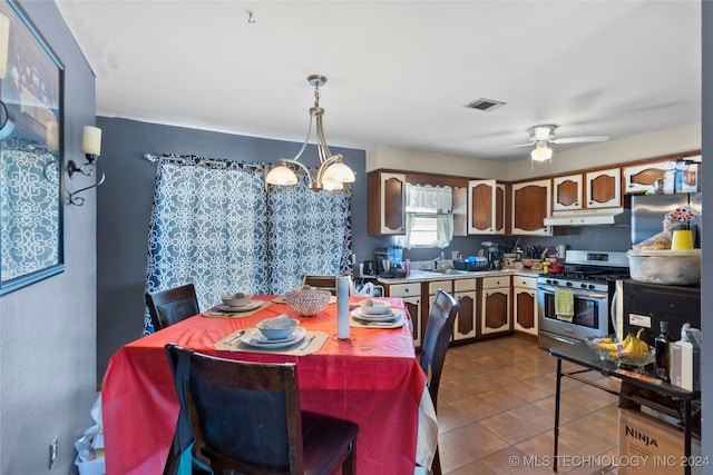 tiled dining space featuring ceiling fan with notable chandelier