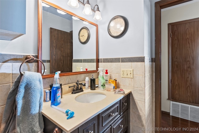 bathroom featuring vanity, tile walls, and hardwood / wood-style floors