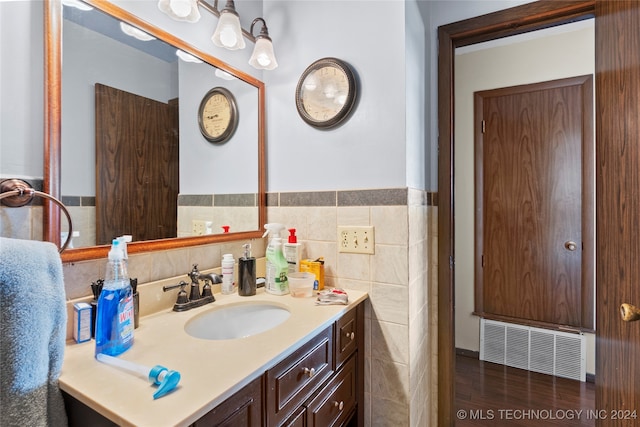 bathroom with vanity, tile walls, and hardwood / wood-style floors