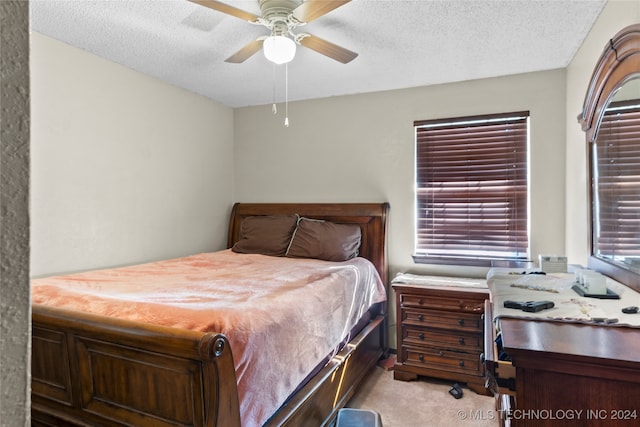 carpeted bedroom featuring a textured ceiling and ceiling fan