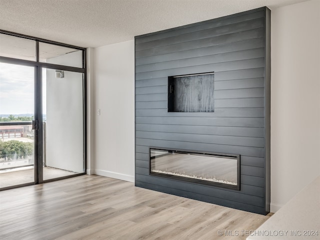 room details with a textured ceiling, wood-type flooring, and a fireplace