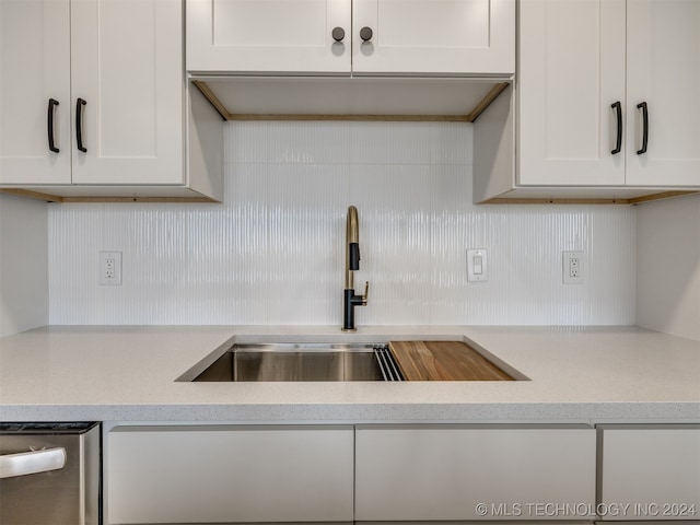 kitchen with white cabinets, sink, and stainless steel dishwasher