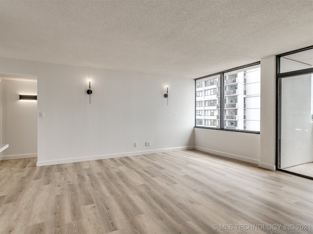 empty room featuring light hardwood / wood-style floors and a textured ceiling