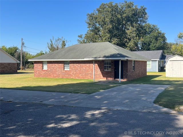 ranch-style house with a storage unit and a front yard