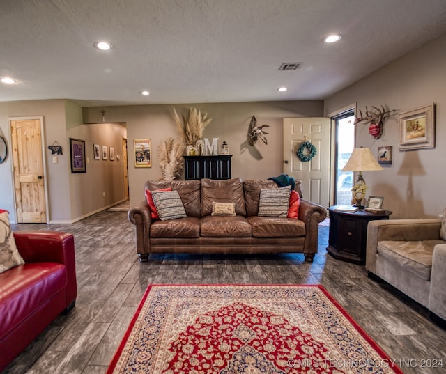 living room featuring a textured ceiling and dark hardwood / wood-style floors