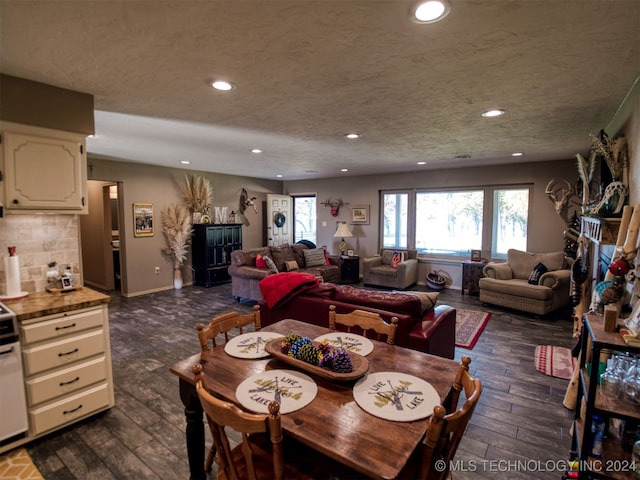 dining space with a textured ceiling and dark hardwood / wood-style floors