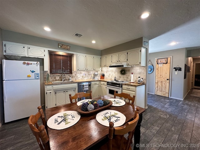 kitchen with decorative backsplash, dark wood-type flooring, white appliances, a textured ceiling, and sink