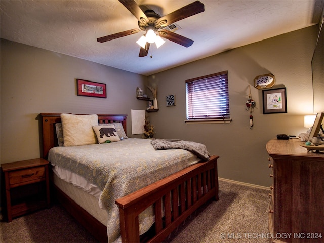 bedroom featuring ceiling fan, carpet floors, and a textured ceiling