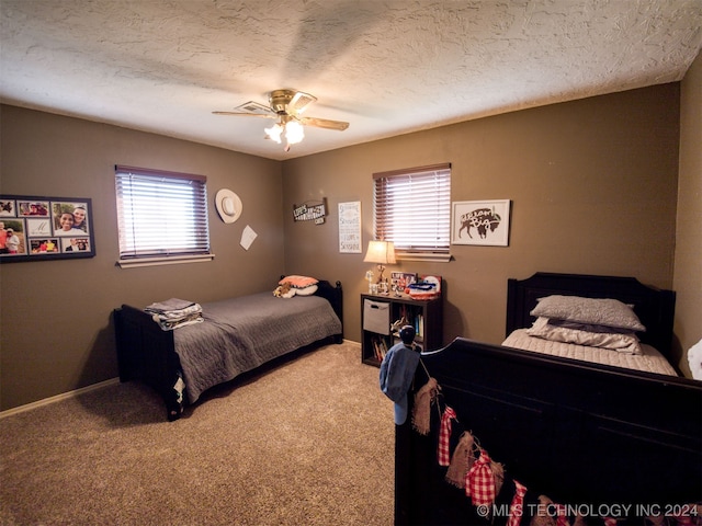 carpeted bedroom featuring multiple windows, a textured ceiling, and ceiling fan