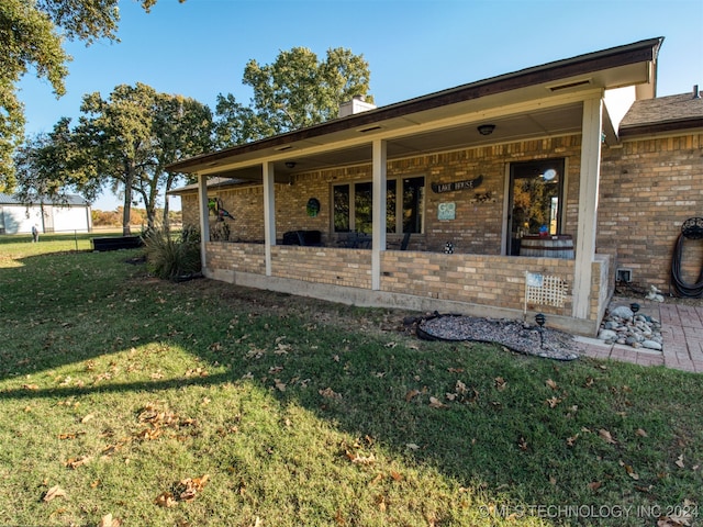 rear view of house featuring a lawn