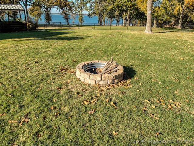 view of yard with a water view and an outdoor fire pit